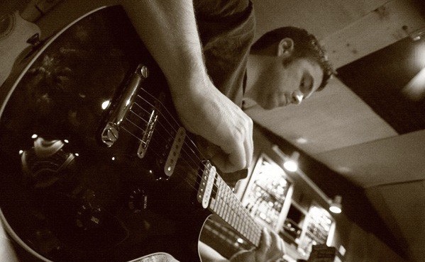 Clyde Rose playing guitar in a recording studio early in his career